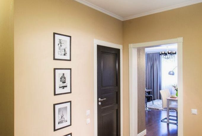 Холл создает первое впечатление о квартире. Стены выполнены в классическом оформлении – высокие белые плинтуса, потолочный багет, паркет-доска из ценных пород дерева. И как изюминка – черные двери с традиционной филенкой с белыми проемами и наличниками.